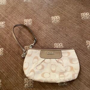 Coach wristlet in beige/gold color.